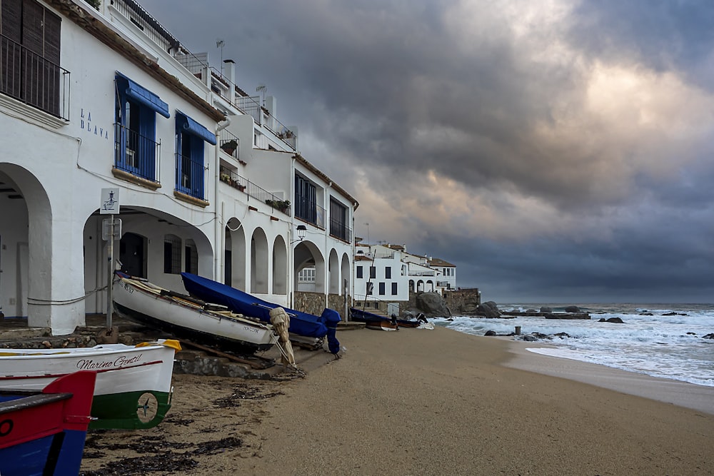 a row of boats sitting on top of a sandy beach