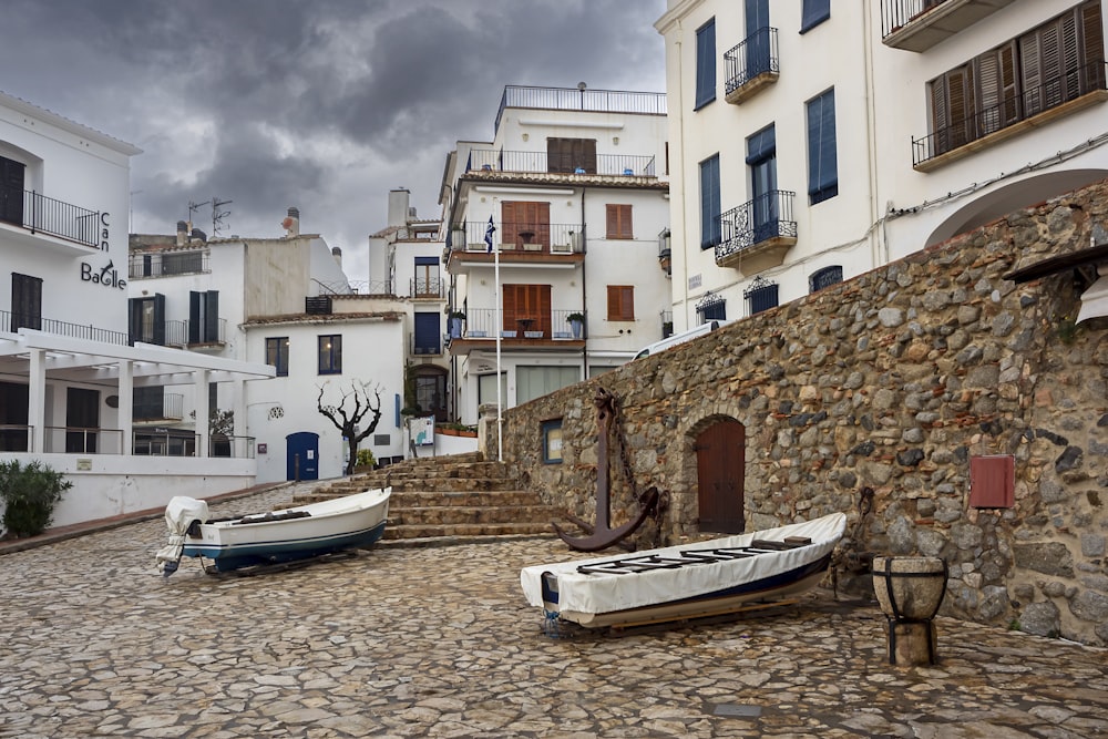 a couple of boats sitting on top of a cobblestone street