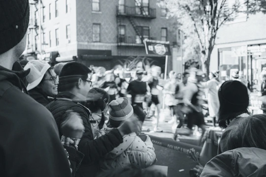 Wide-angle photo of marathon runners crossing a city street lined with cheering spectators.