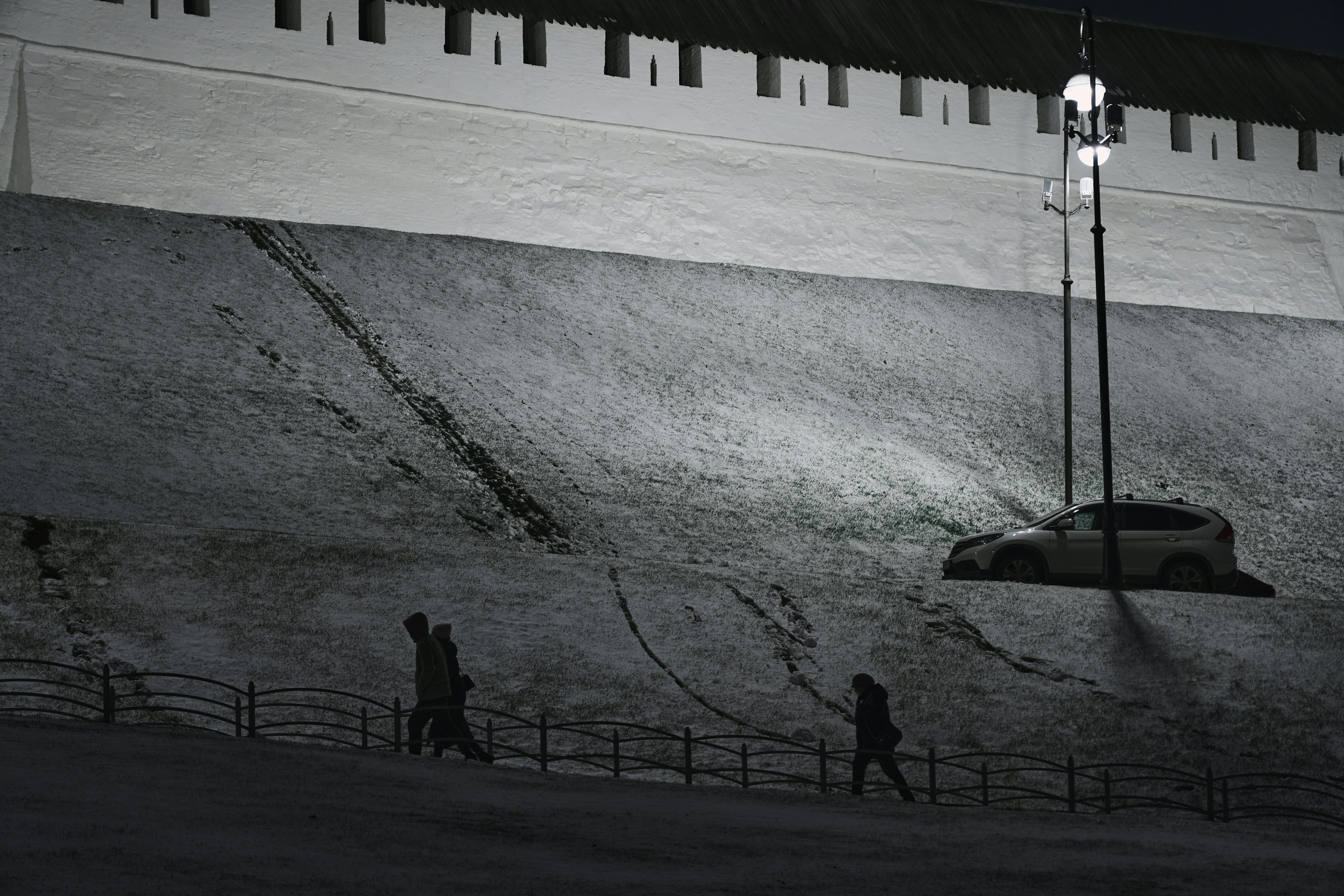 Estadio europeo con nieve y luces en partido nocturno