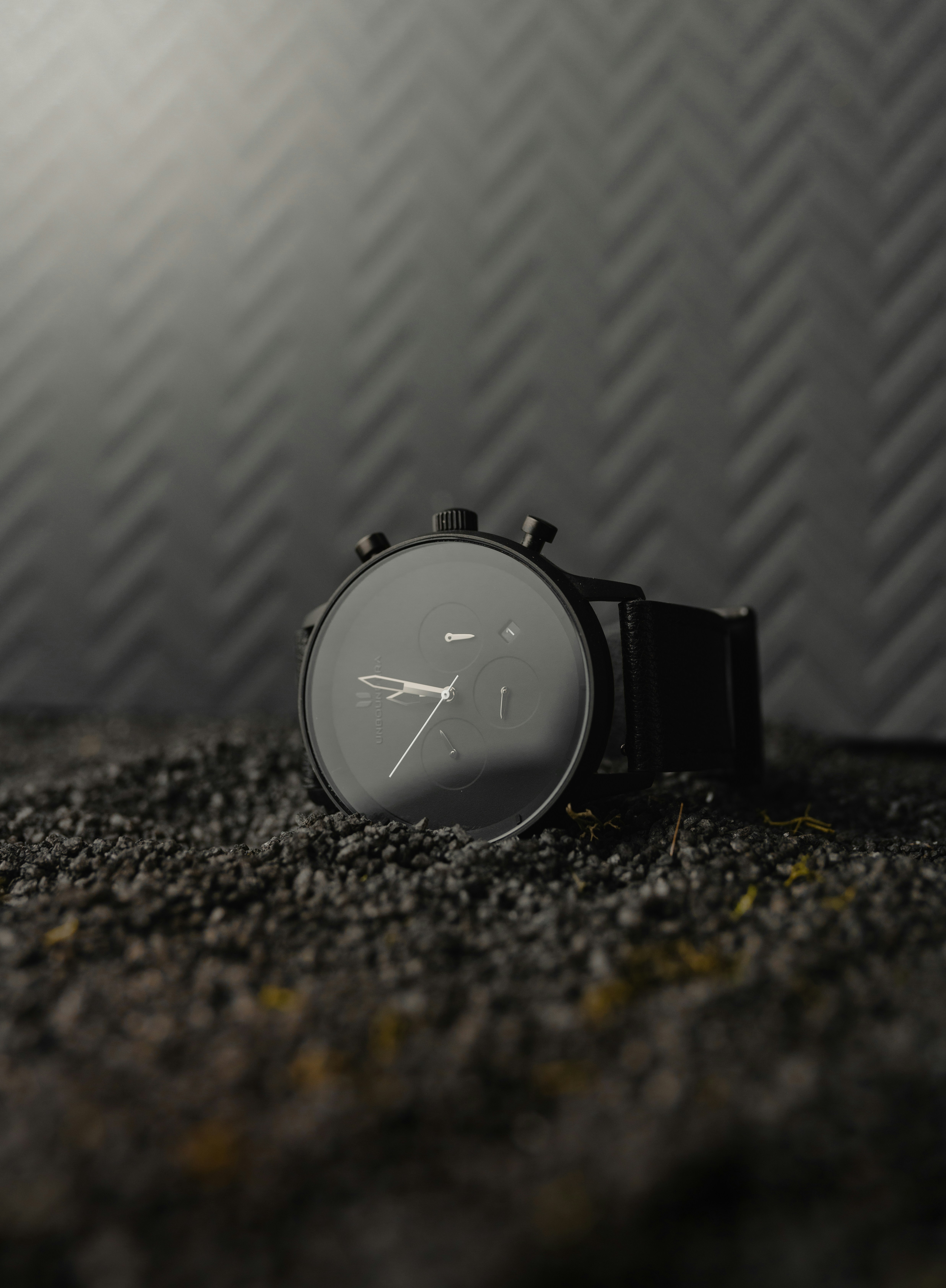 a watch sitting on the ground in front of a wall