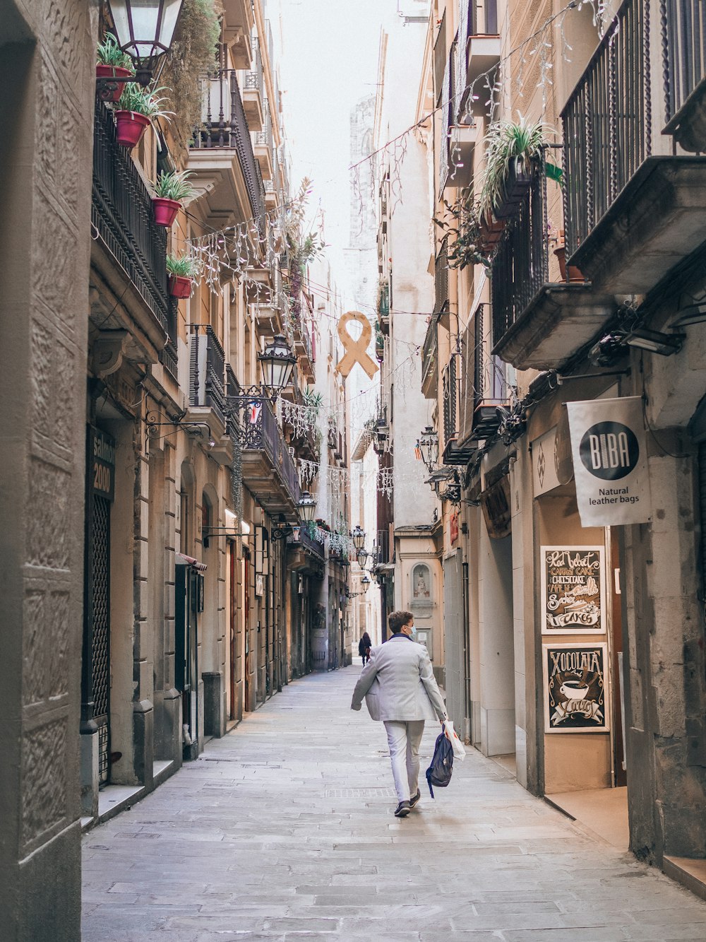 a man walking down a street next to tall buildings