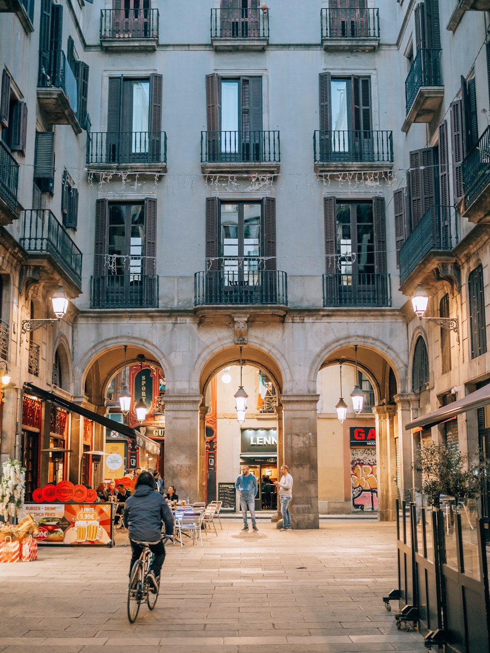 a person riding a bike through a courtyard