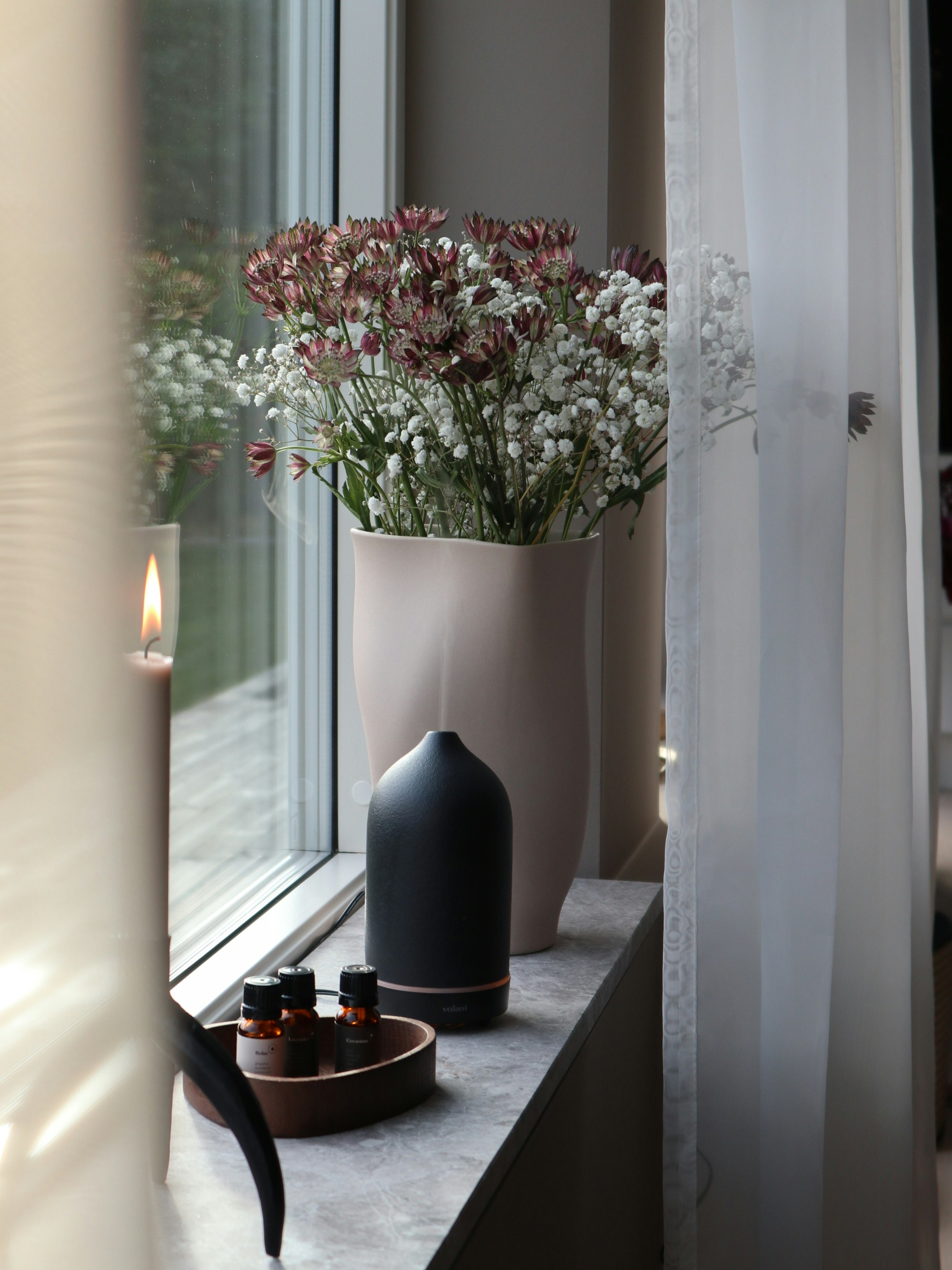 a vase filled with flowers sitting on a window sill