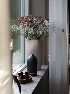 a vase filled with flowers sitting on a window sill