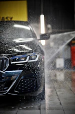 a car is being sprayed with water by a sprayer