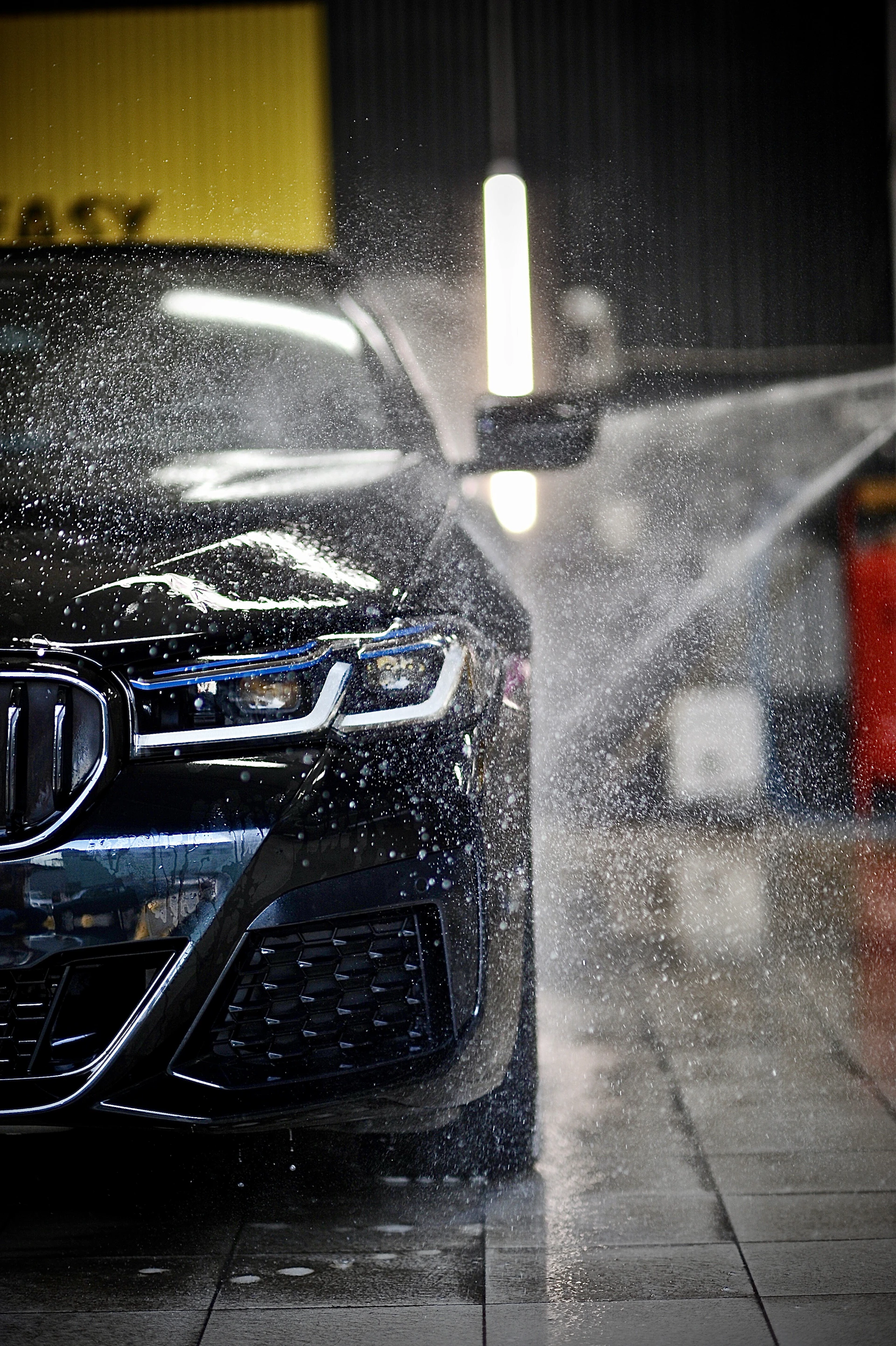 a car is being sprayed with water by a sprayer