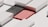 A geometric composition featuring rectangular and square shapes in a minimalist style. The image includes a black, textured rectangle alongside a smooth, red rectangle, surrounded by light gray structures that add a three-dimensional effect with shadows.