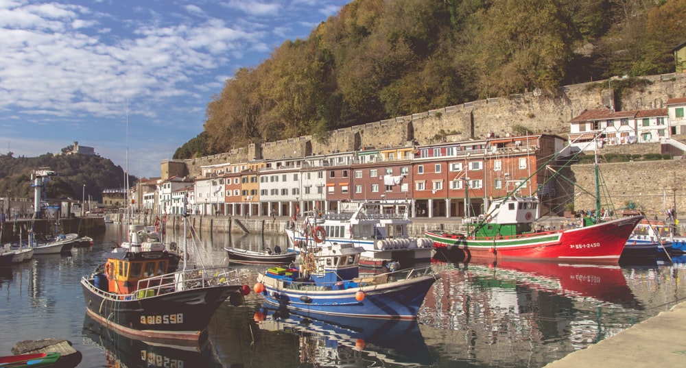 a harbor filled with lots of boats next to a hillside