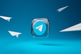 A prominent Telegram app logo is set in the center against a vibrant blue background, surrounded by four minimalist paper airplane illustrations, suggesting themes of communication and connectivity.