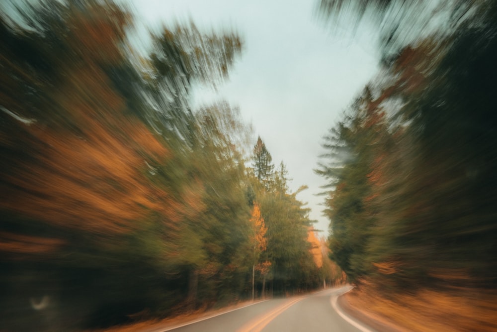 a blurry photo of a road with trees in the background