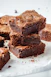 a pile of brownies sitting on top of a white plate