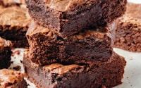 a pile of brownies sitting on top of a white plate