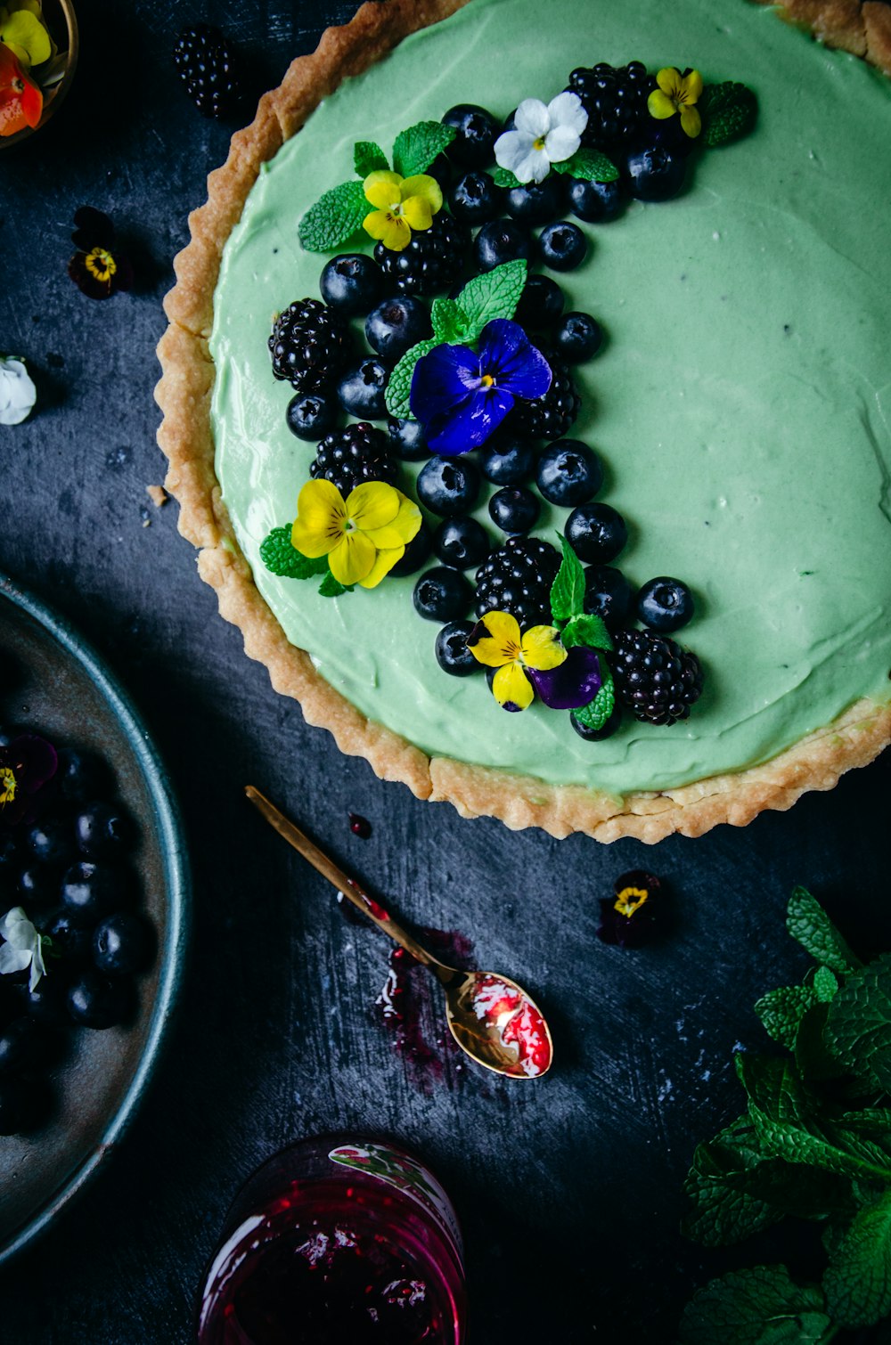 a pie with blueberries, raspberries, and flowers on it
