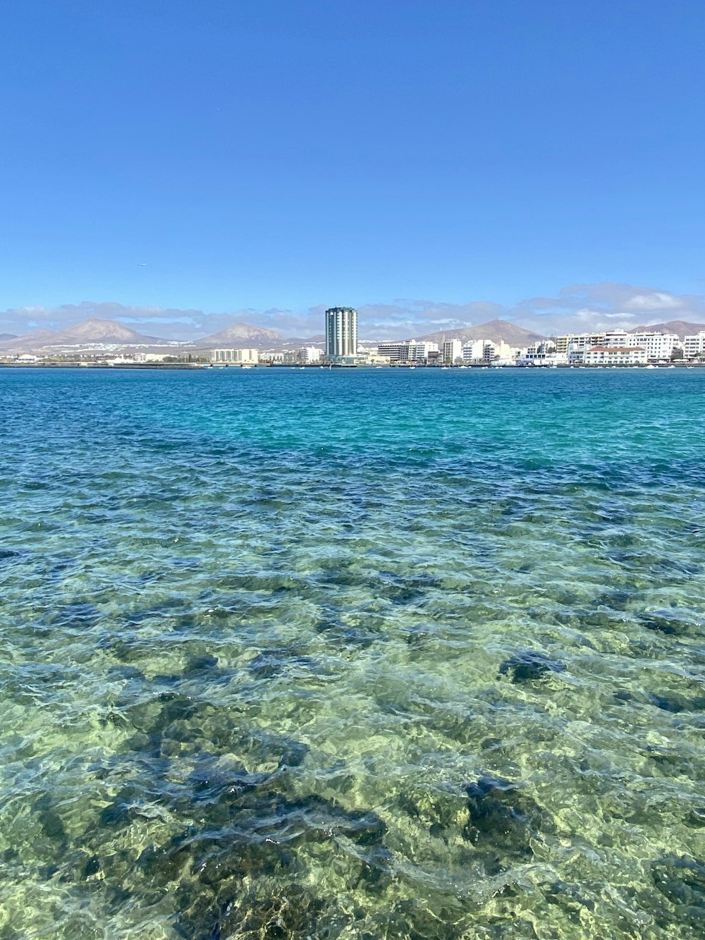 a body of water with a city in the background