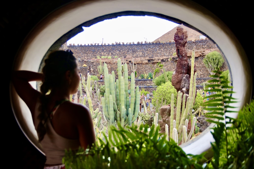 a woman in a white dress looking out a window