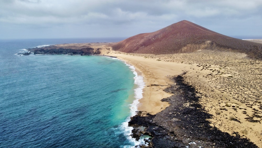 Luftaufnahme eines Strandes mit einem Berg im Hintergrund