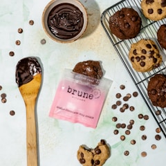 Assortment of chocolate chip cookies with melting chocolate chunks on a white plate.