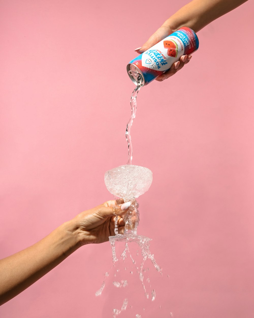 a person is pouring water from a can into a glass