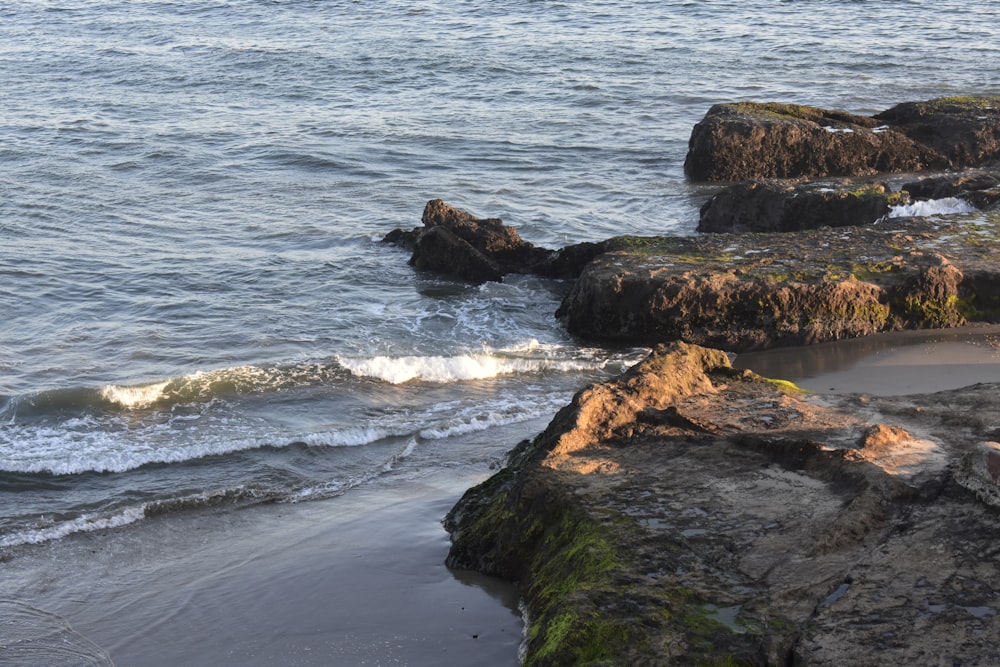 a rocky beach with waves coming in and out of the water