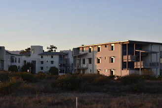 a group of buildings sitting next to each other in a field