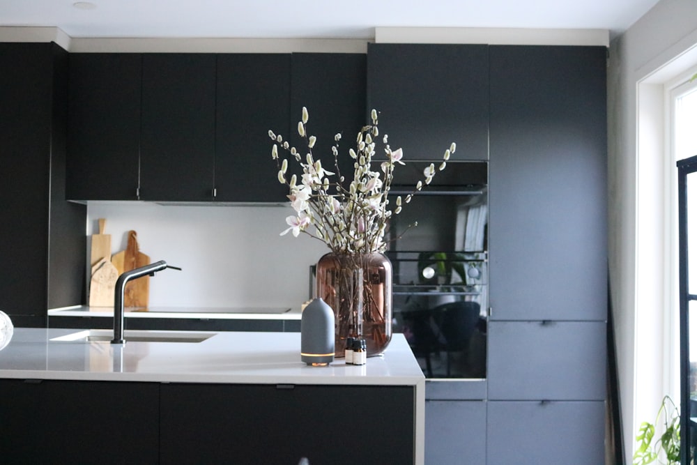 a vase of flowers sitting on a kitchen counter