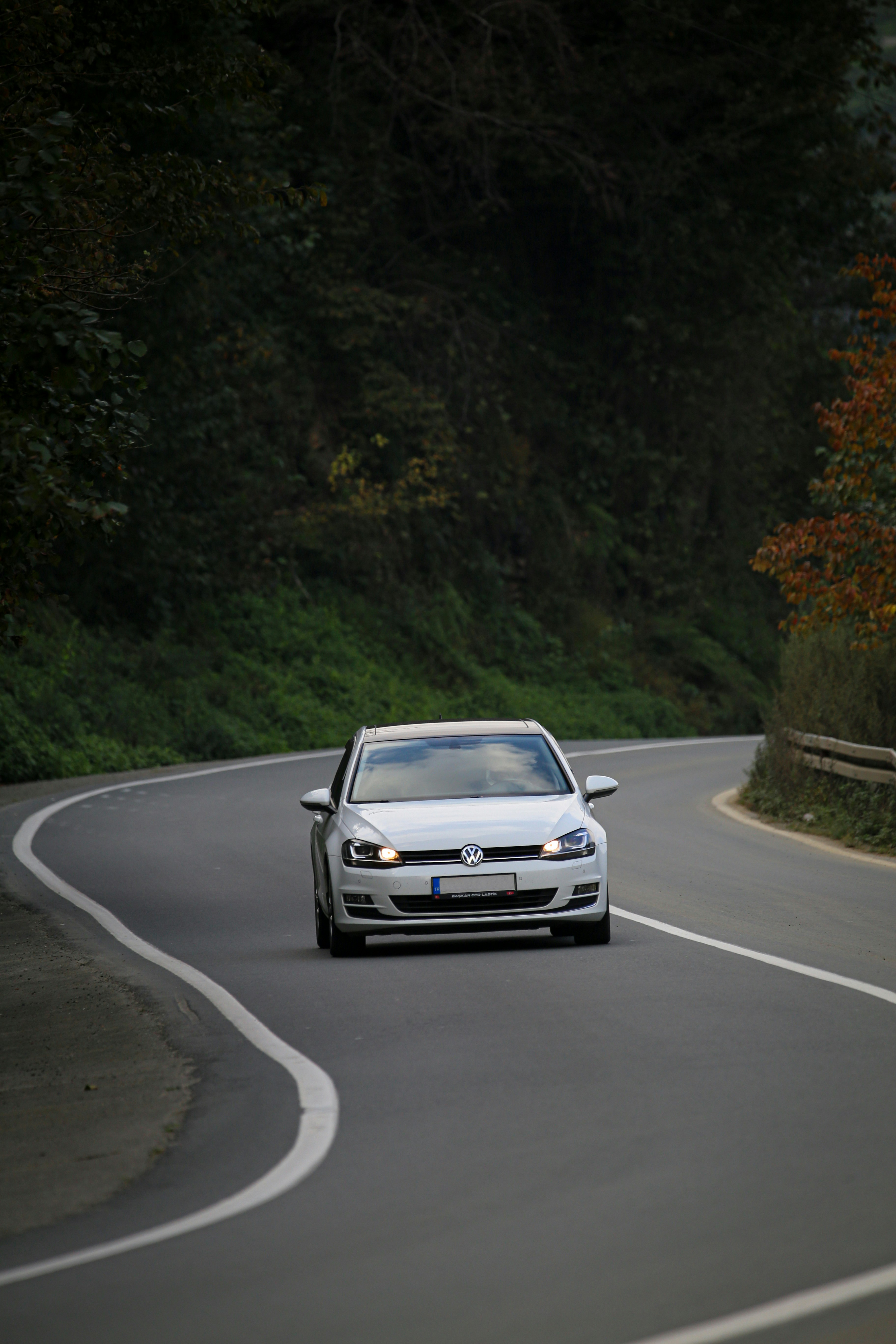 a white car driving down a winding road