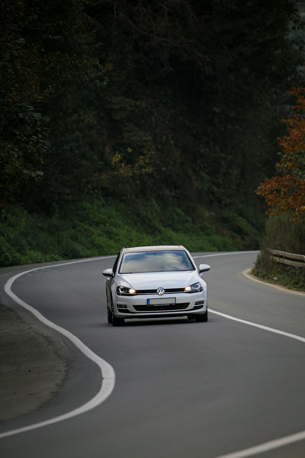 a white car driving down a winding road