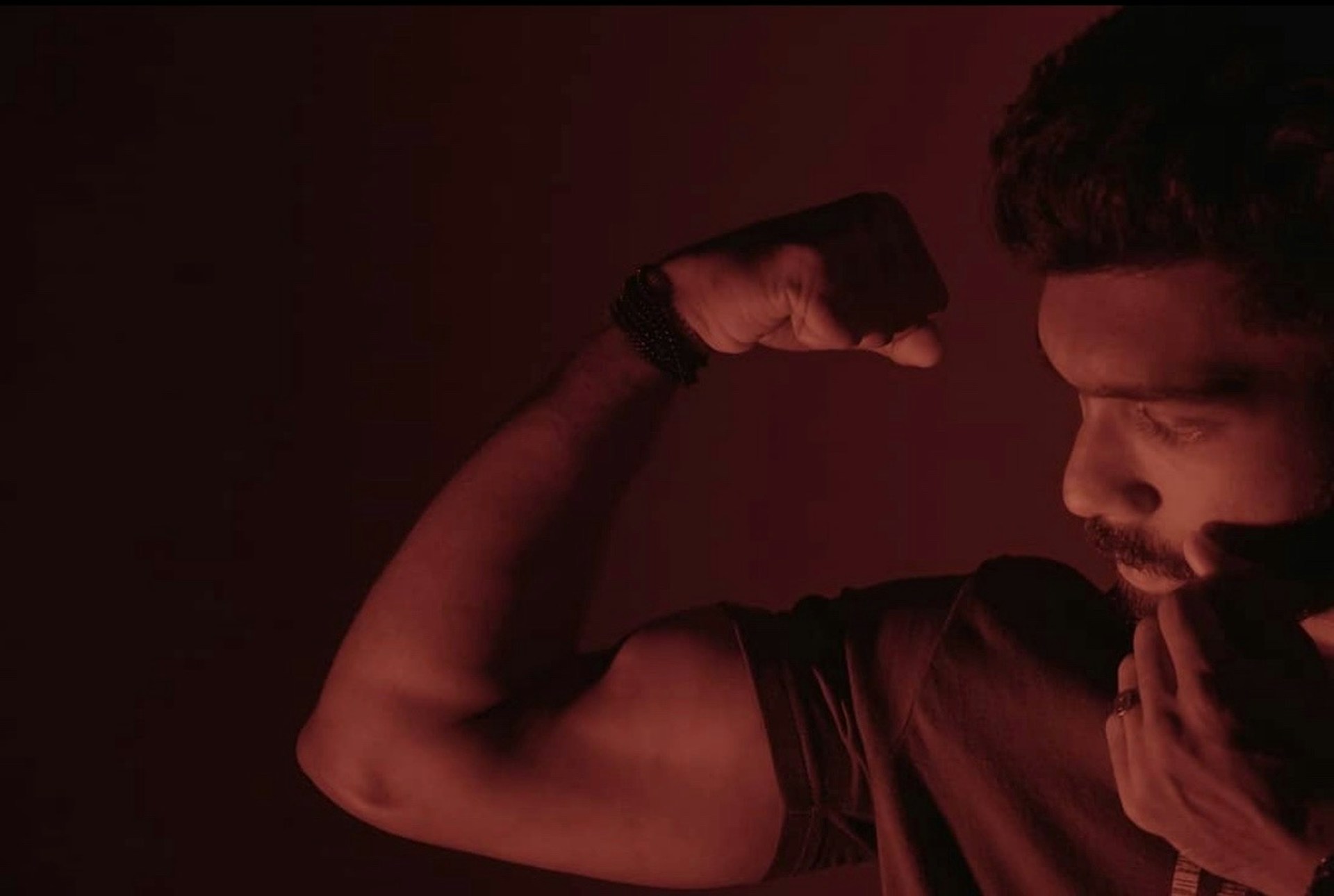 Close-up of a client proudly flexing their transformed physique, highlighting the results of disciplined training and nutrition.