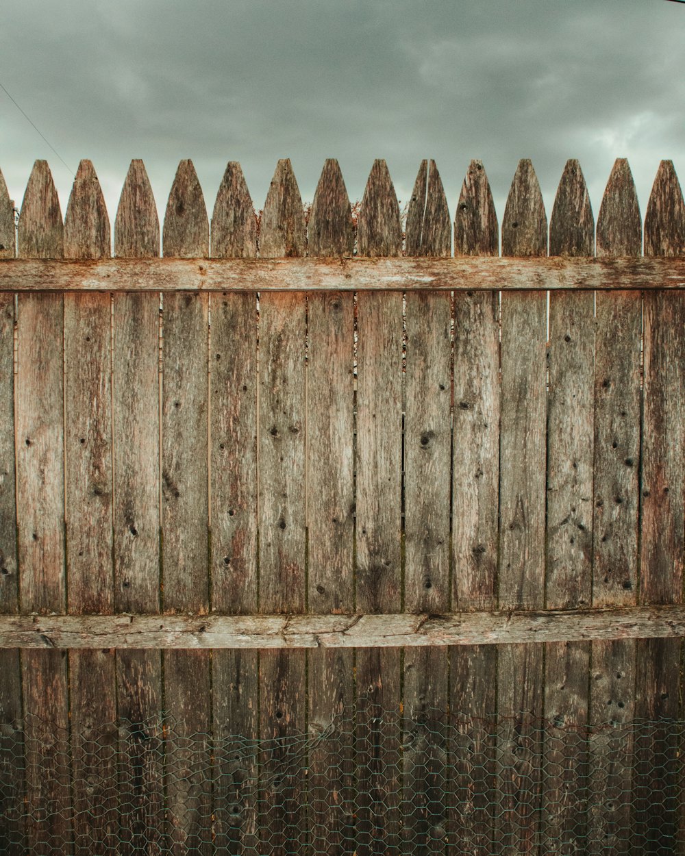 Stained wood fence against a blue sky