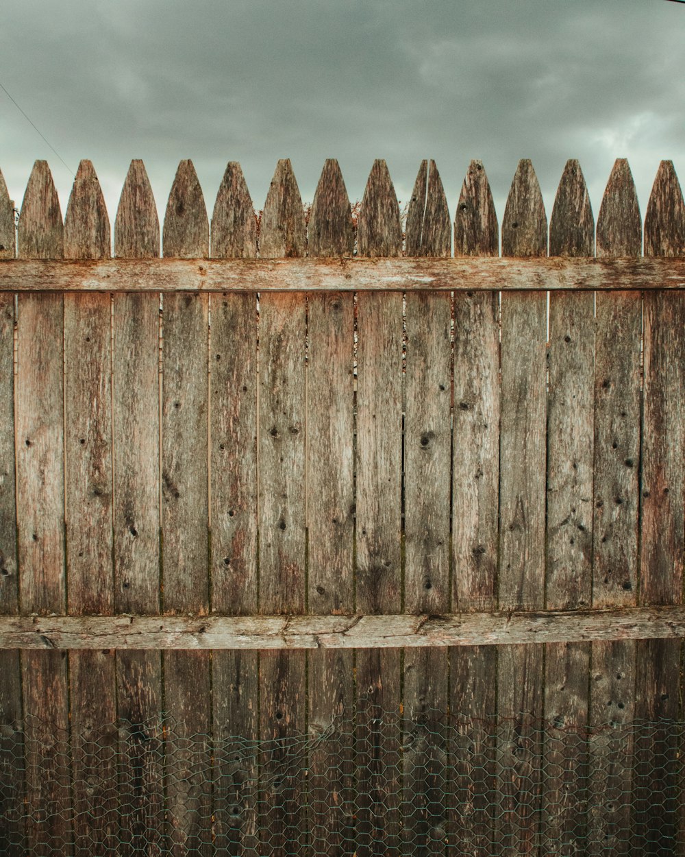 a wooden fence is reflected in the water