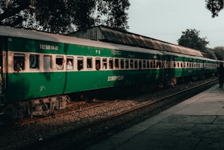 a green passenger train sitting on top of train tracks