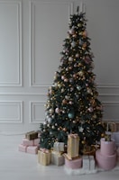 An elegant blush pink Christmas tree surrounded by wrapped gifts and vintage ornaments.