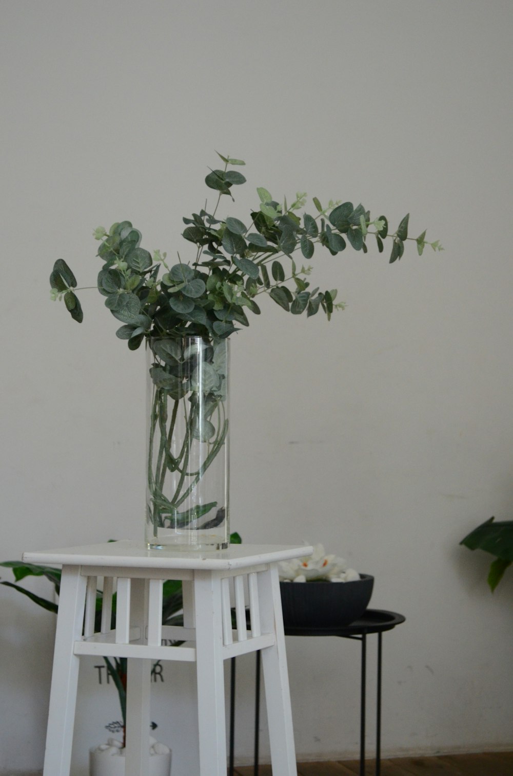 una mesa blanca con un jarrón de flores encima