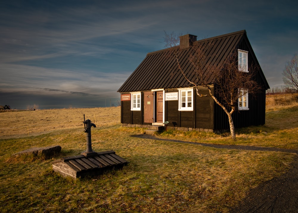 a small house with a cross in front of it