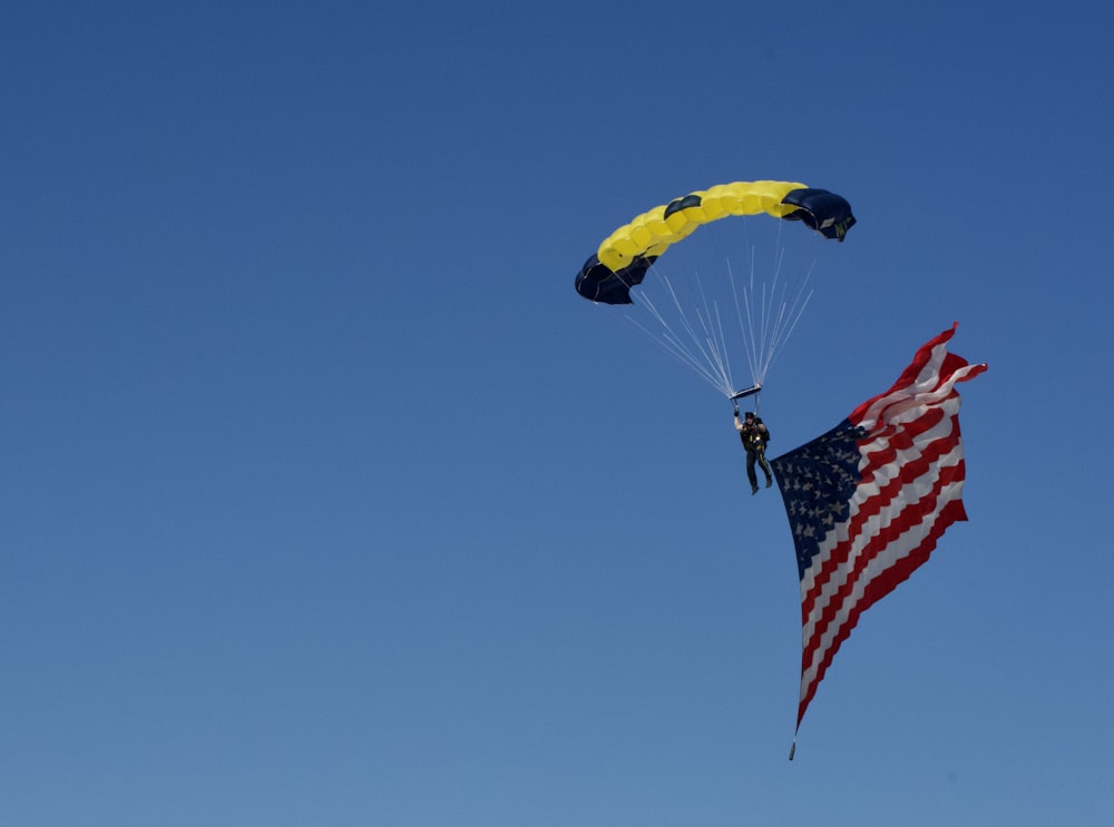 uma pessoa está parasailing no céu com uma bandeira americana