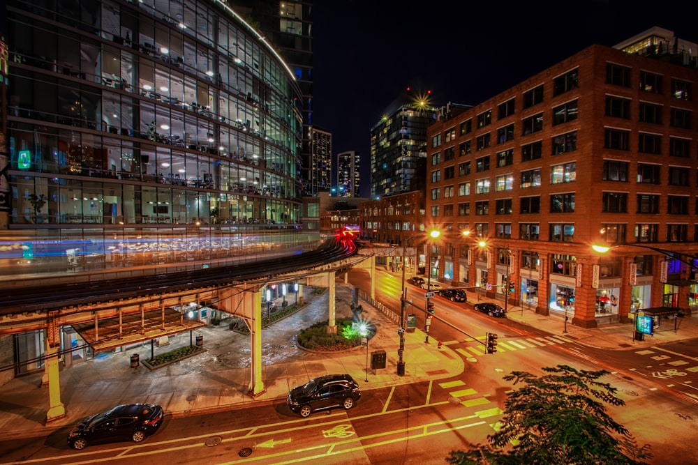 a city street at night with cars driving on it