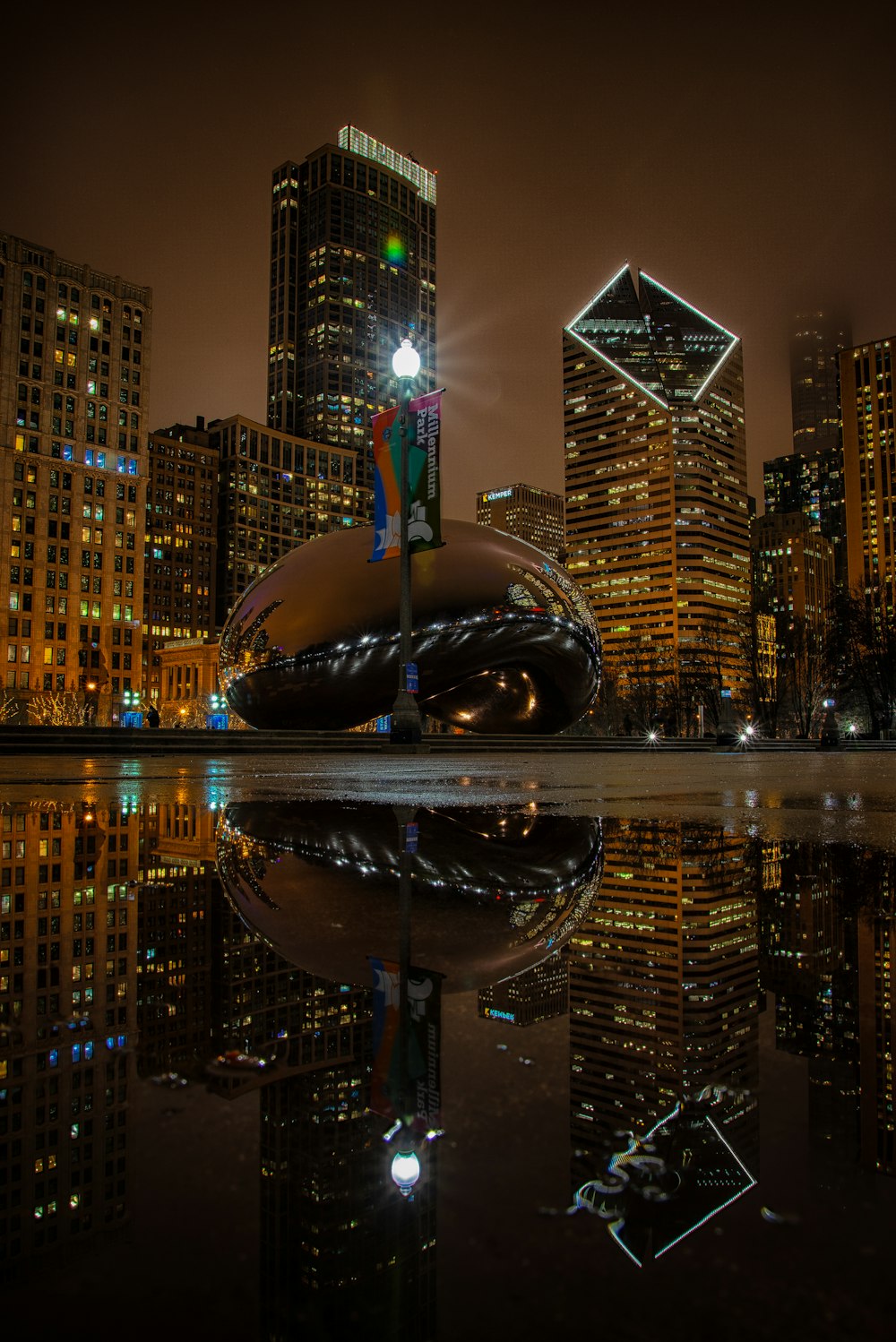 a city at night with skyscrapers reflected in the water