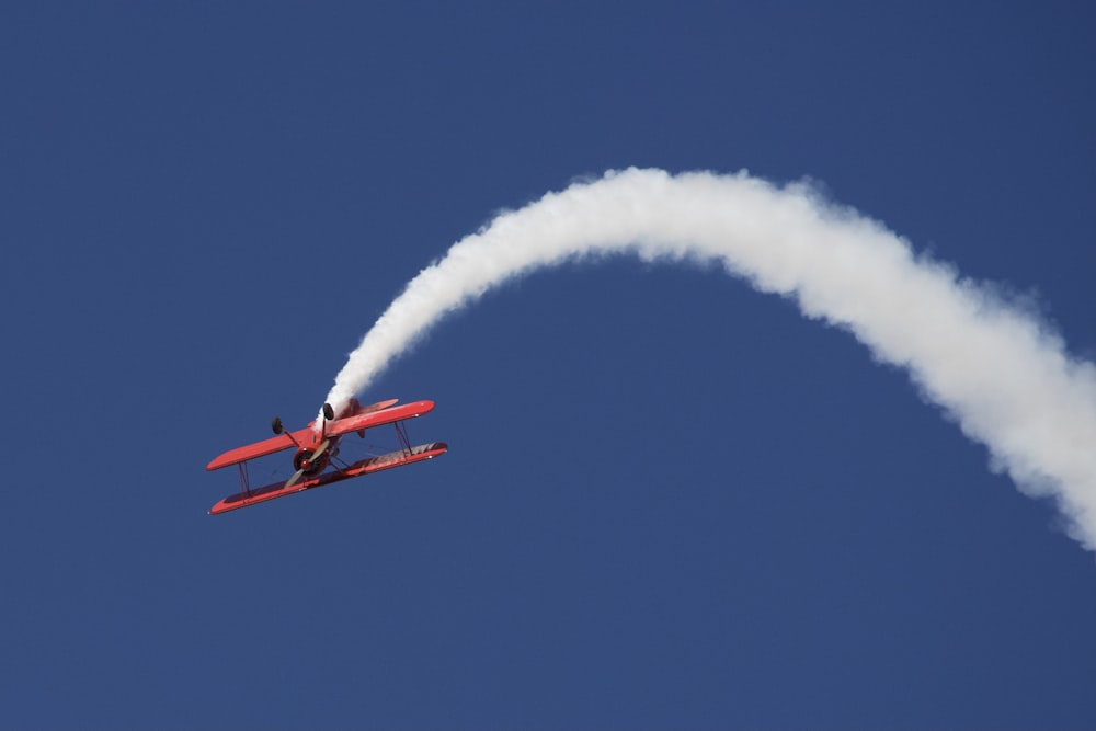 a small plane flying through a blue sky