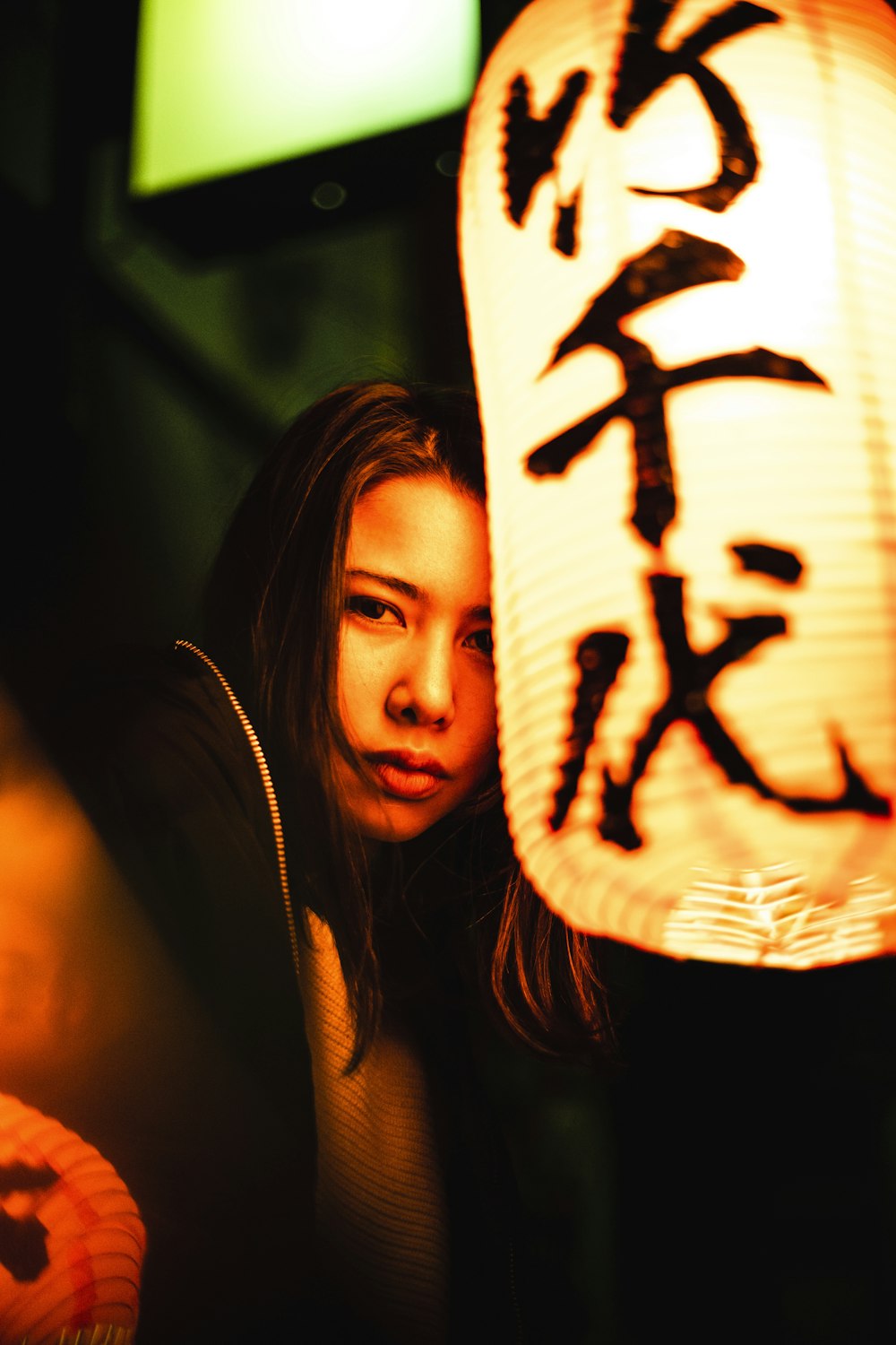 a woman holding a lantern in front of her face