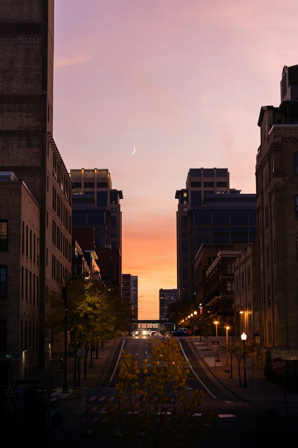 the sun is setting over a city street