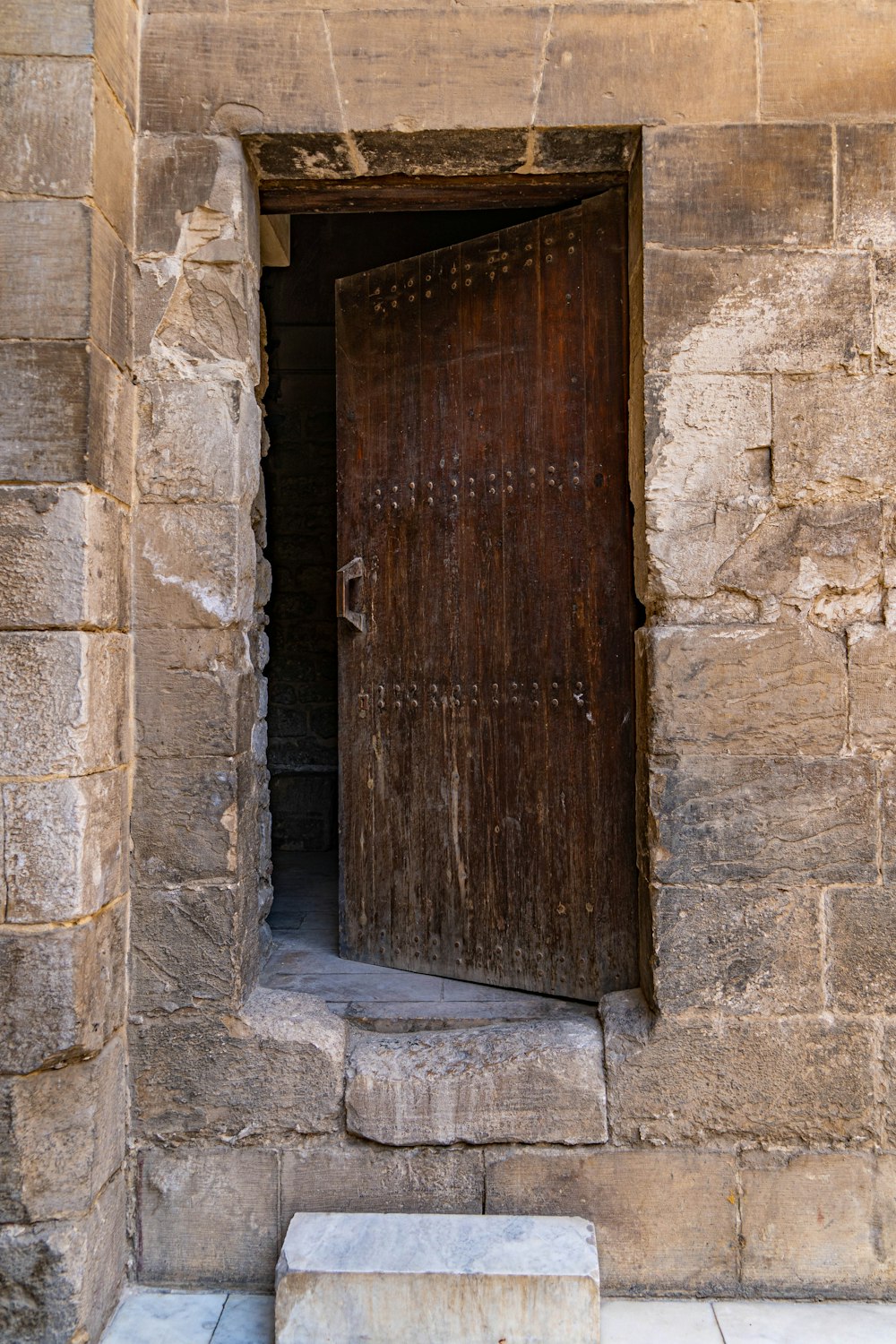 a wooden door is open on a stone building