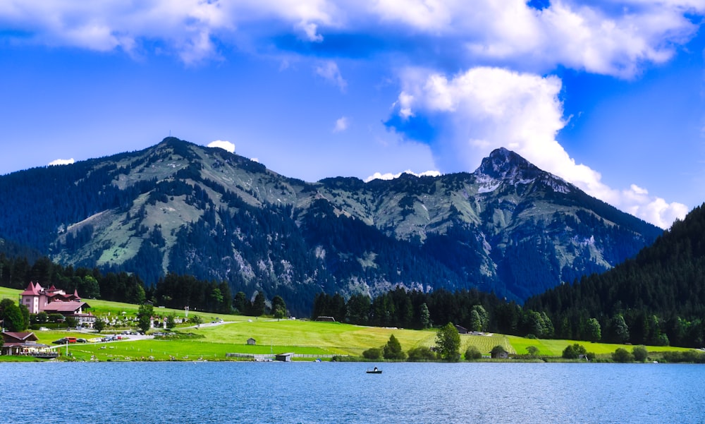 a scenic view of a mountain range with a lake in the foreground