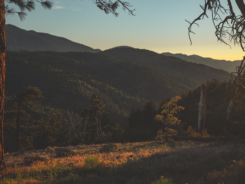 the sun is setting over the mountains in the distance