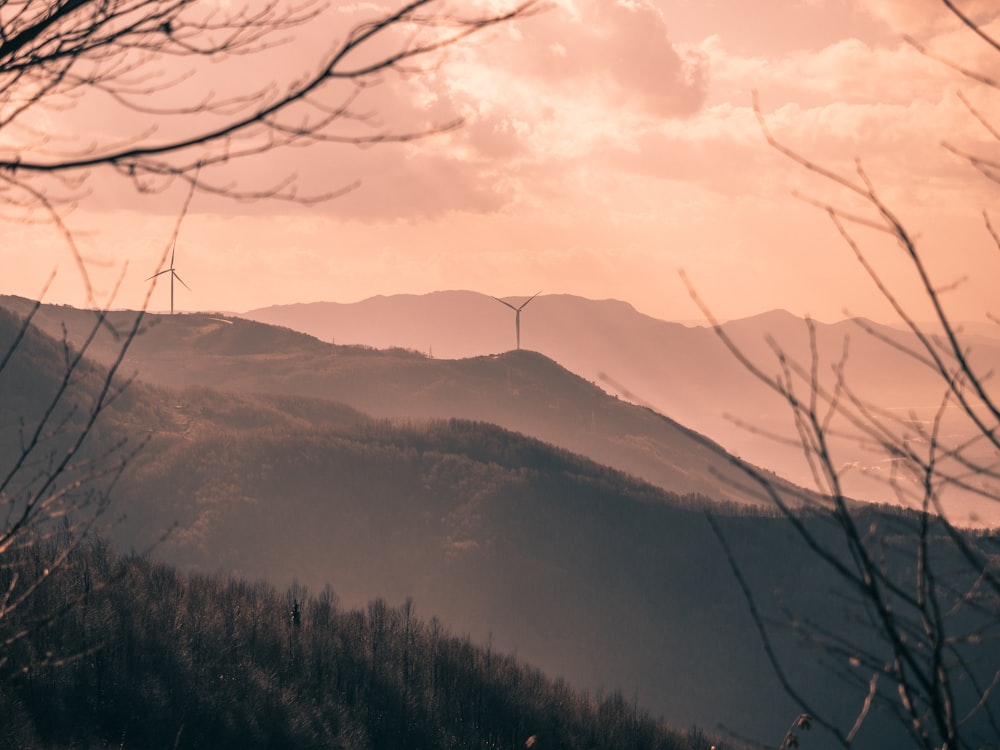 a view of a mountain with a wind turbine in the distance