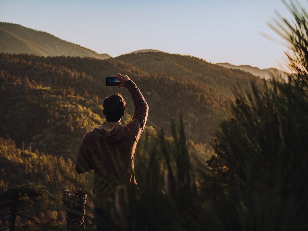a man taking a picture of a mountain range