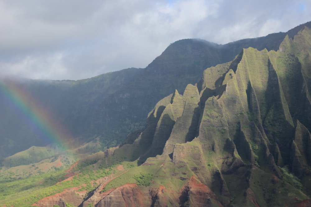 a rainbow in the sky over a mountain range