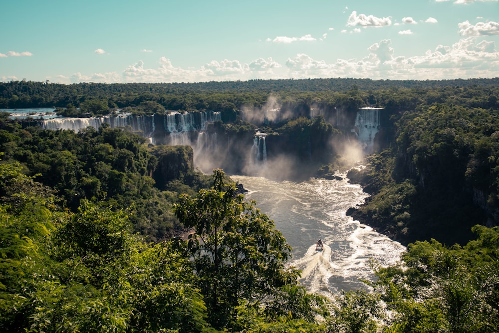 a large waterfall surrounded by lush green trees