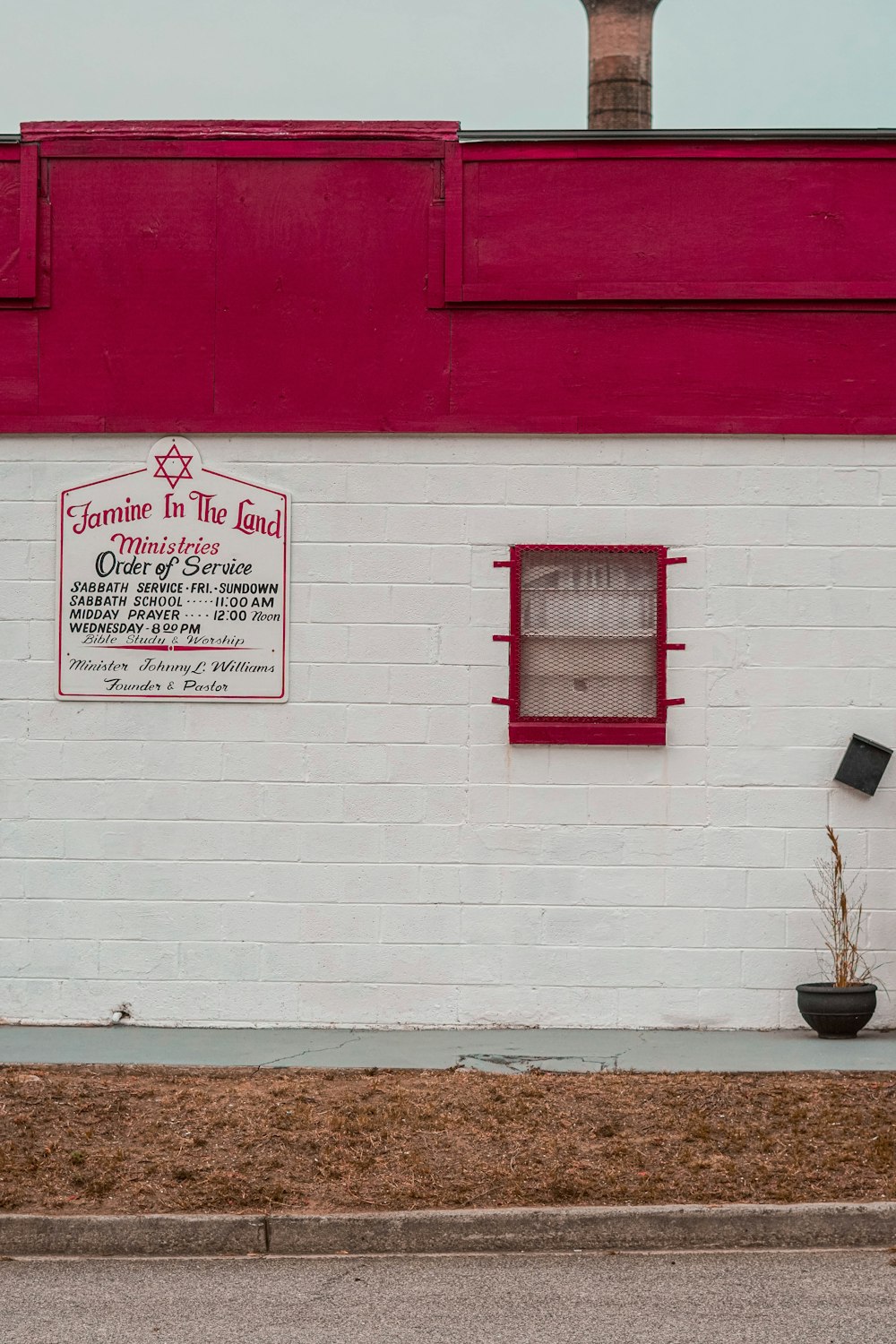 a white brick building with a red roof