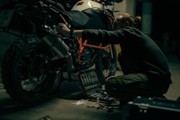 a man working on a motorcycle in a garage
